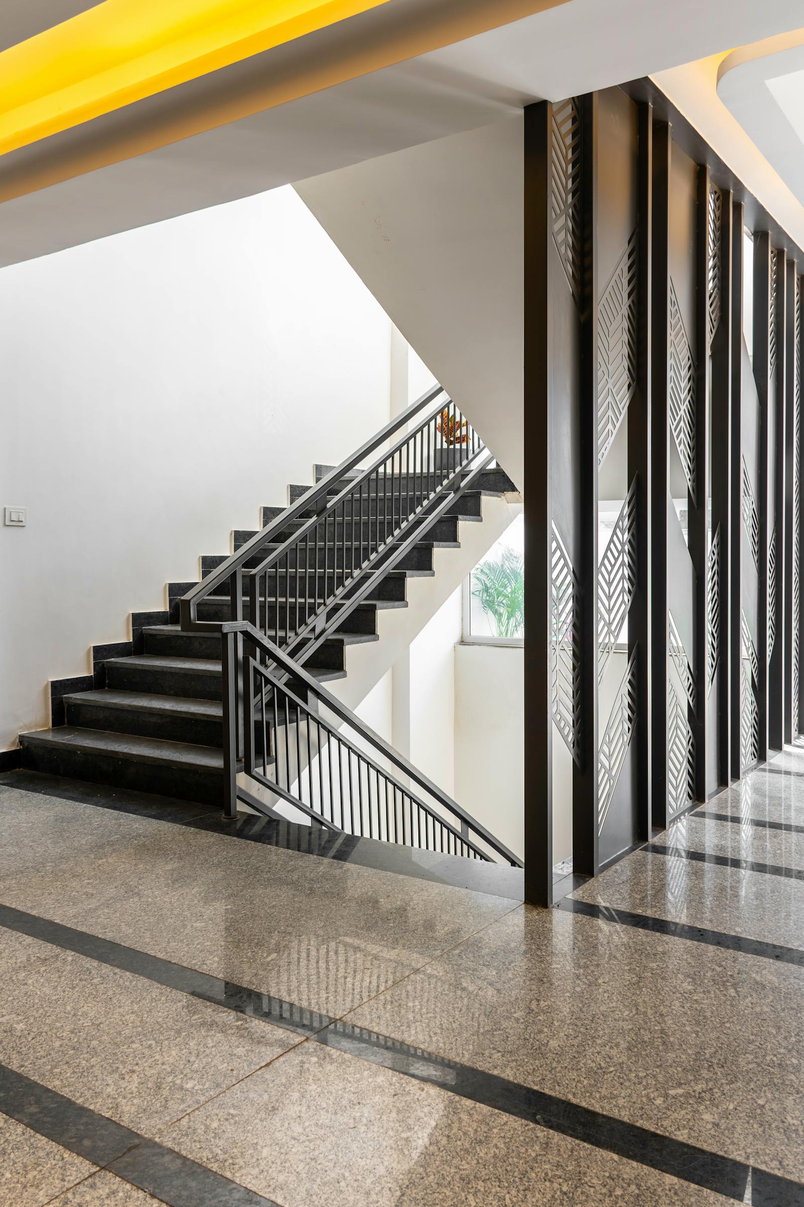 Sweeping stair of a brutalist concrete museum lit by a single high window, a figure ascending the second flight.